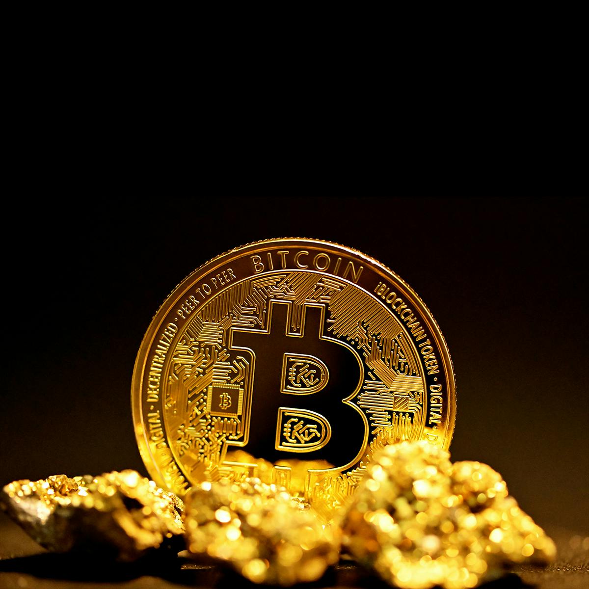 Bitcoin on top of a small pile of gold
