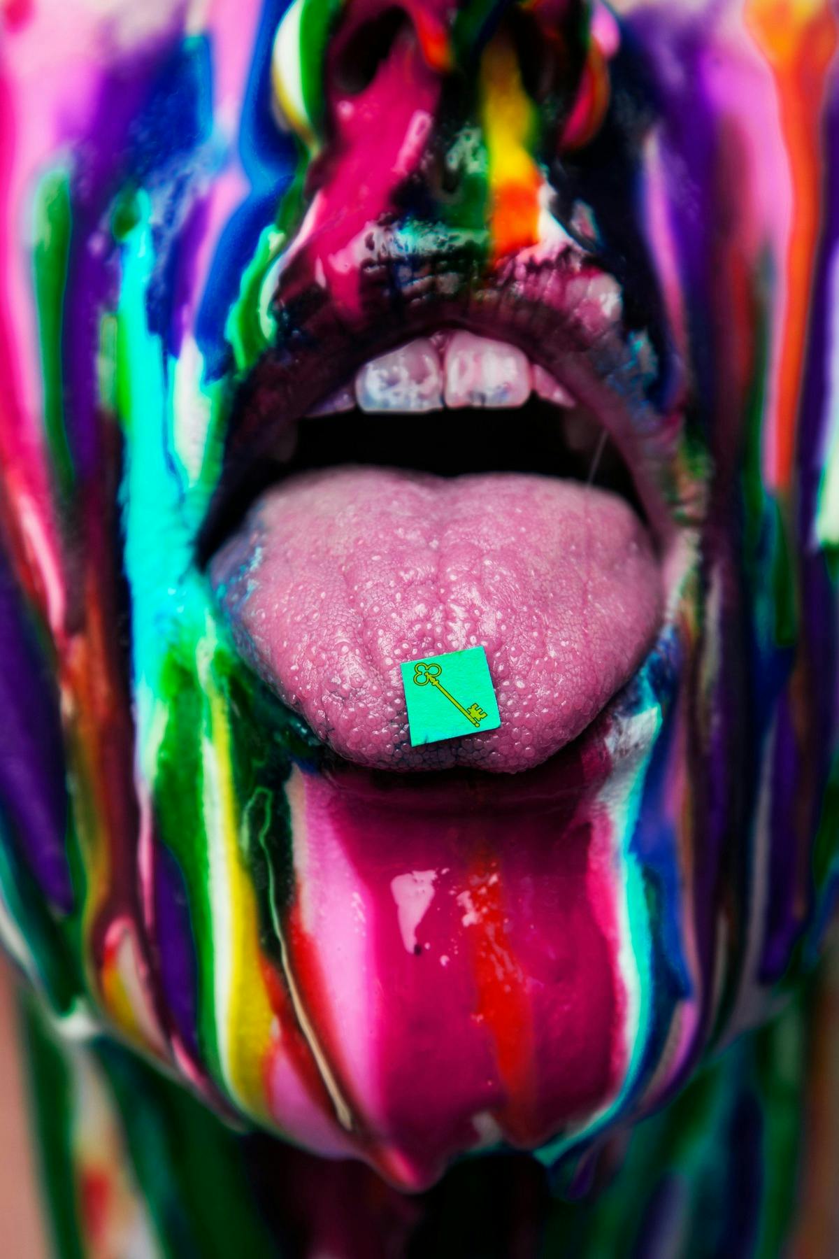 Photo of person holding a tab of acid on their tongue. 