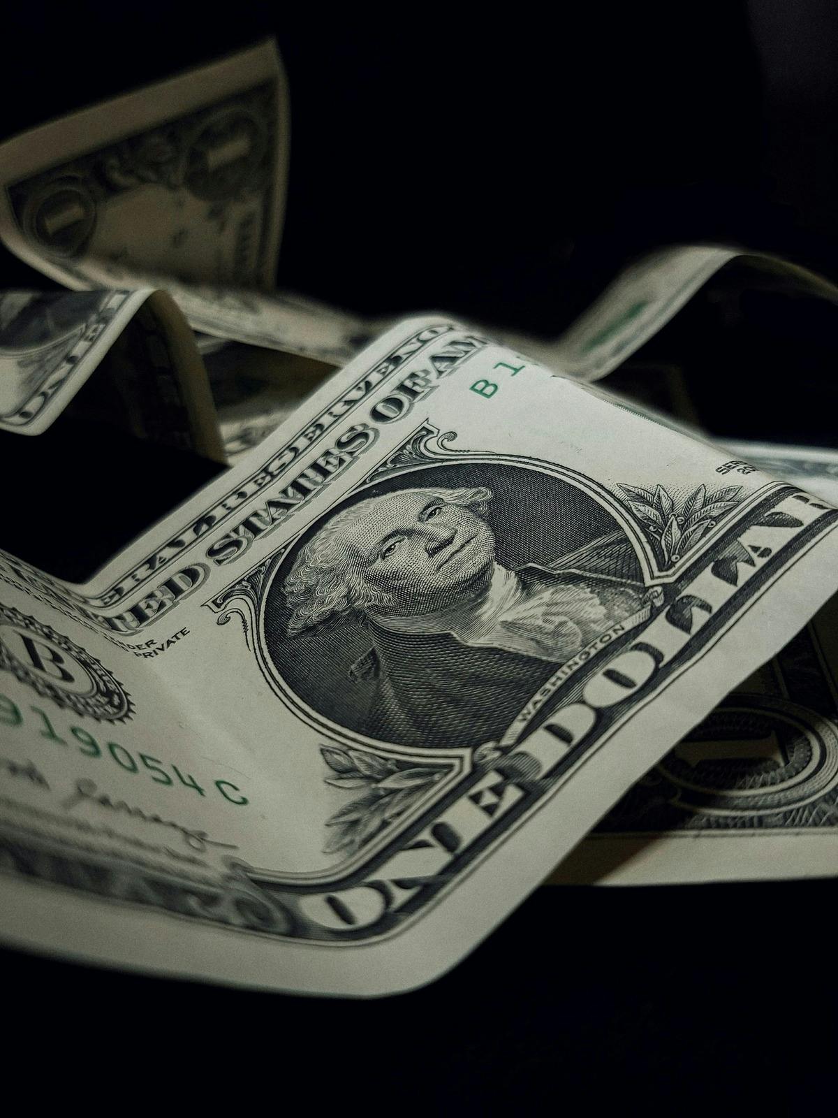 Closeup photo of pile of US dollar bills.