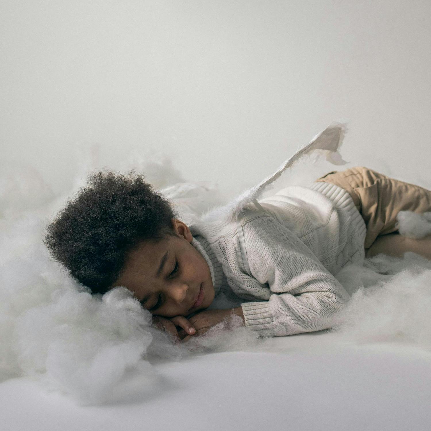 Photo of a winged child sleeping on clouds.
