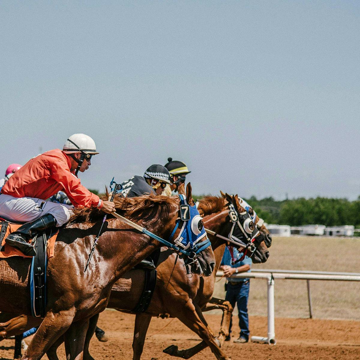 Jockeys on horse back racing